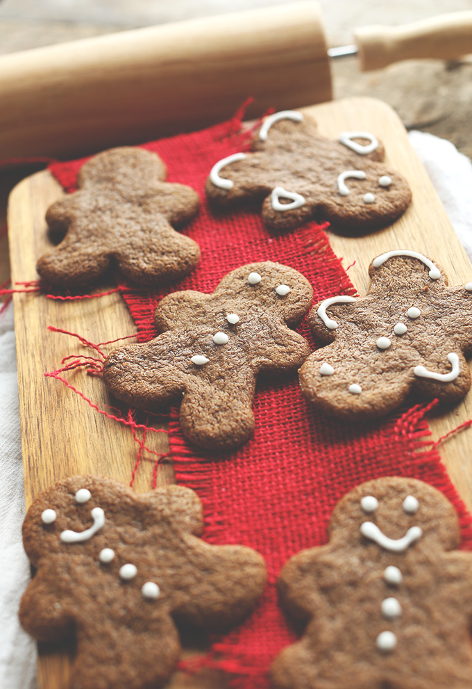 Wood cutting board with a batch of our decorated Gingerbread Cookies