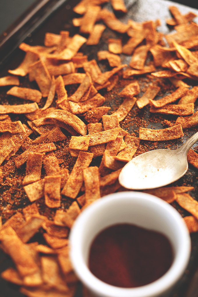 Baking sheet with a bowl of spices and and scattering of Homemade Chili Cheese Fritos