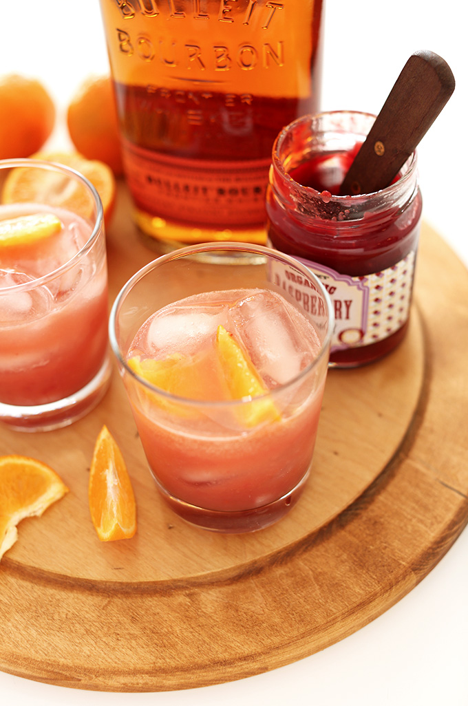 Cutting board with ingredients and glasses for our Raspberry Jam Bourbon Smash recipe