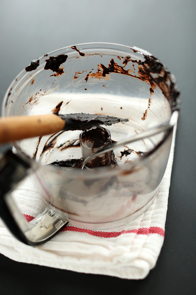 Rubber spatula resting in a food processor scraped of brownie batter