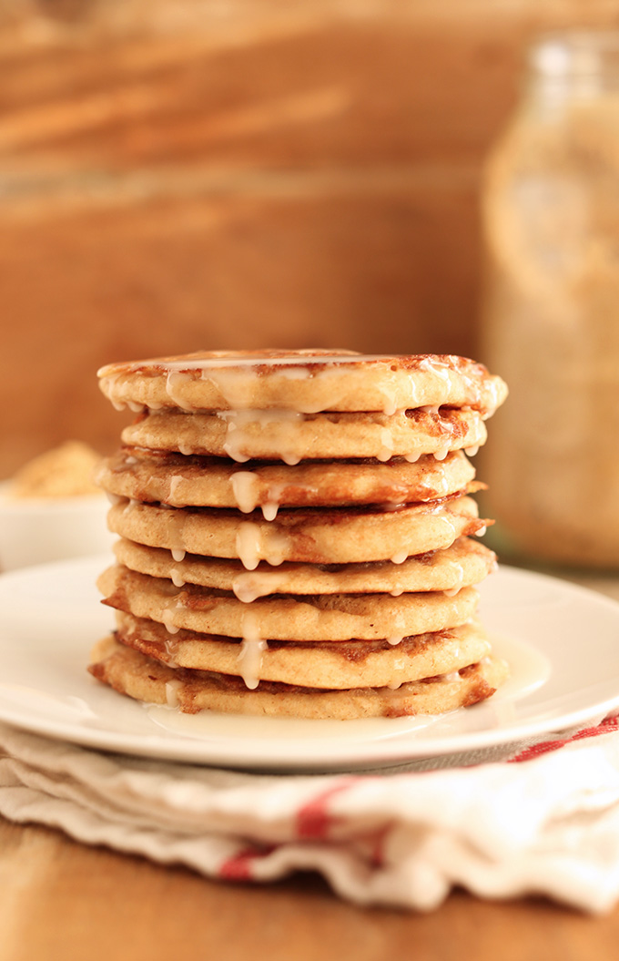 Stack of Vegan Cinnamon Roll Pancakes with icing dripping down the side