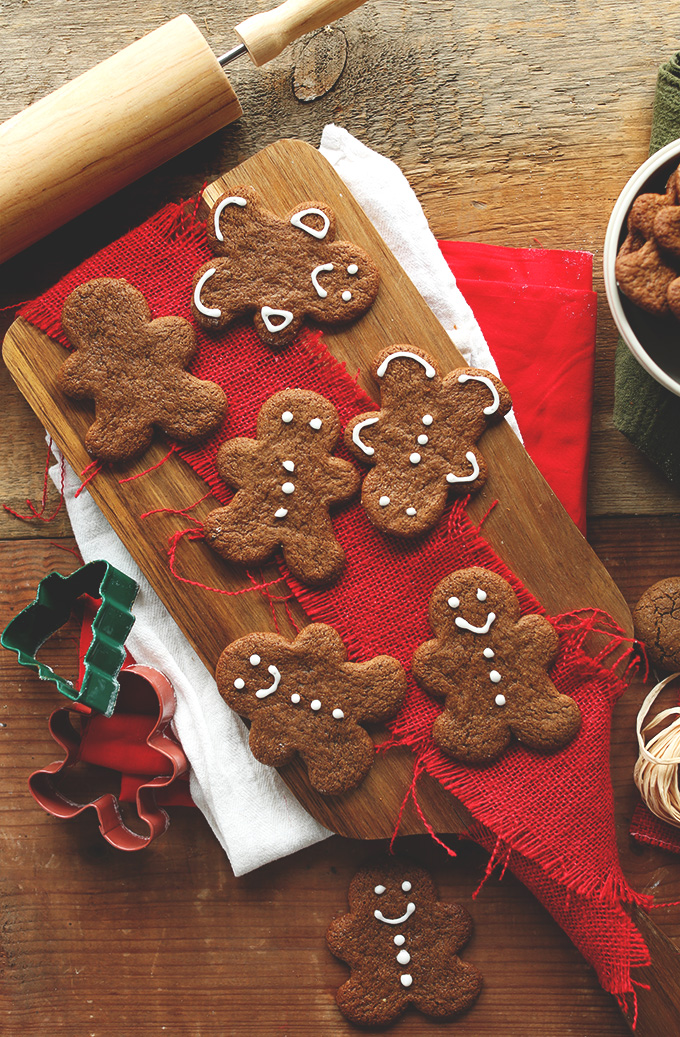 Partially decorated Vegan Gluten-Free Gingerbread Cookies on a cutting board