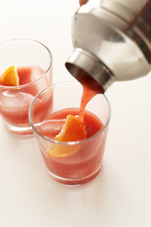 Pouring two glasses of Raspberry Winter Bourbon Smash
