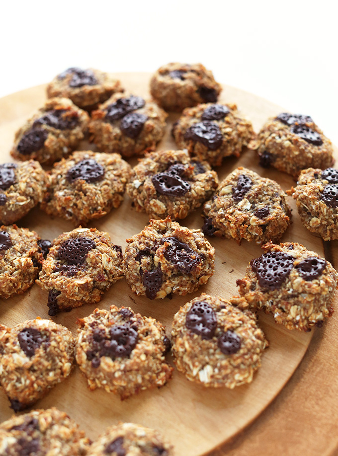 Cutting board filled with Vegan Oatmeal Cookies with dark chocolate on top