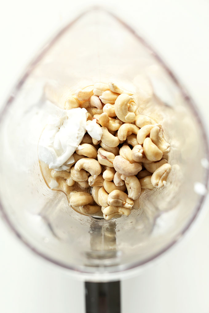 Blender filled with cashews and coconut cream for making Vegan Cheesecake filling