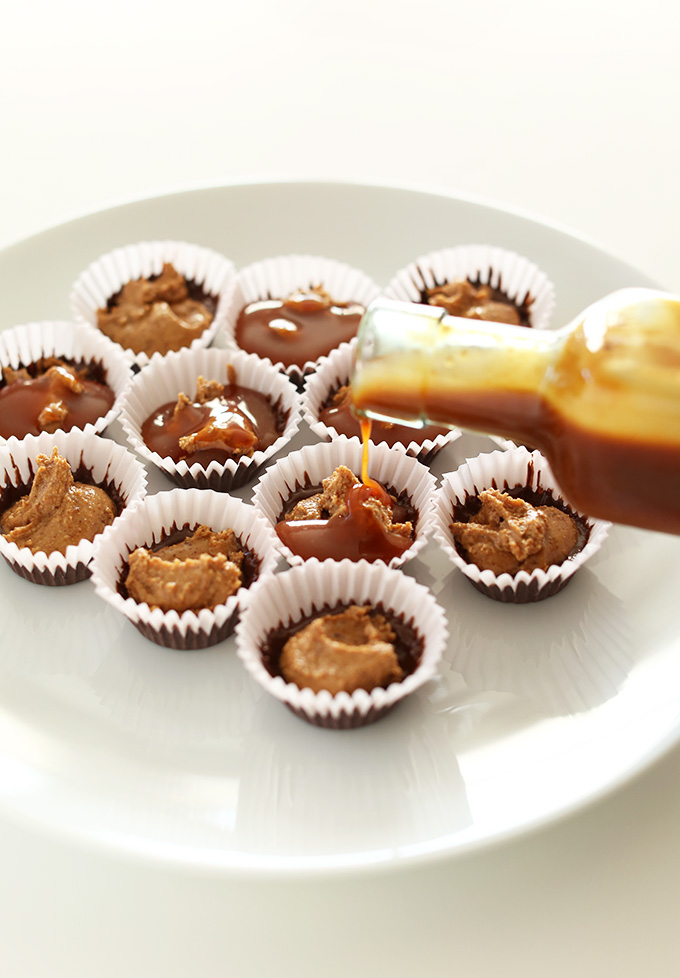 Pouring the bourbon caramel layer over the almond butter layer