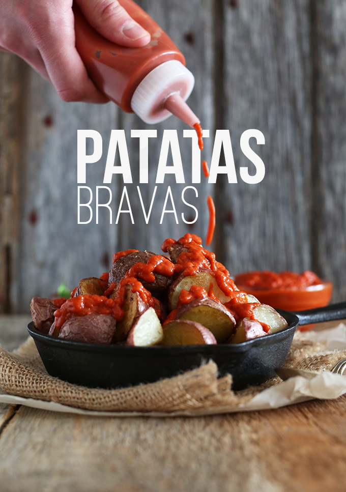 Drizzling sauce onto gluten-free vegan Patatas Bravas