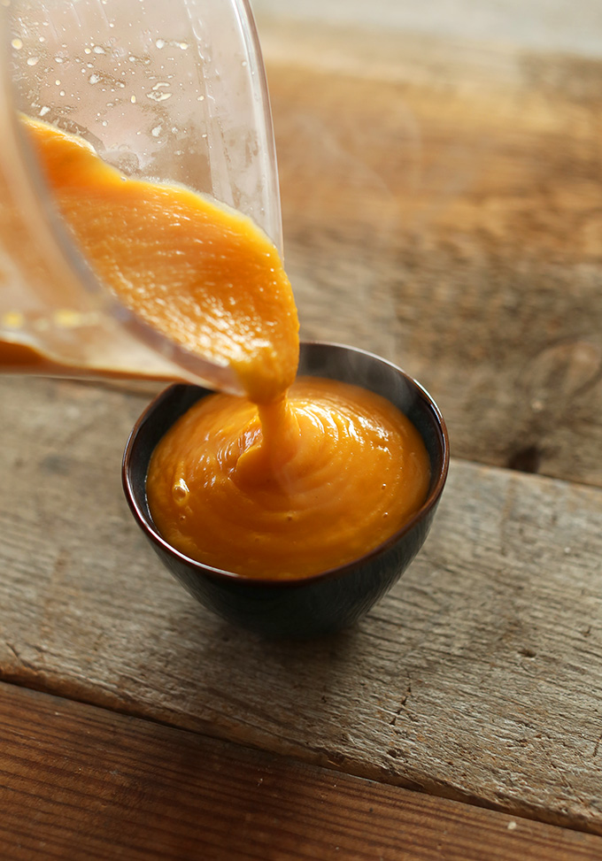 Pouring squash puree into a bowl for Tom Kha Gai Butternut Squash Soup