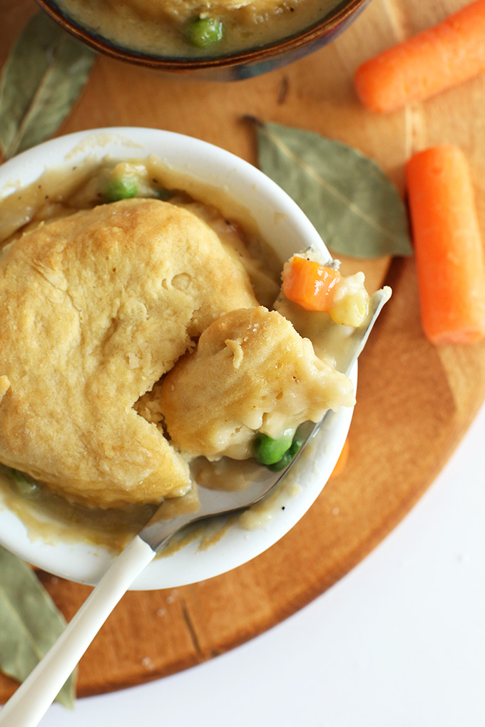Close up shot of a fork with a bite of Vegan Pot Pie resting on a ramekn