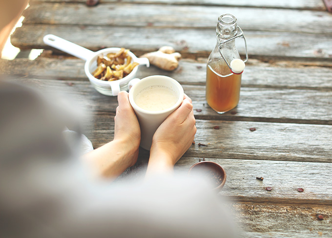 Holding a mug of our warm Ginger Tea Latte recipe
