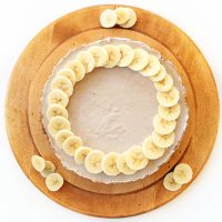 Vegan Gluten-Free Banana Cream Pie on a cutting board with fresh banana slices