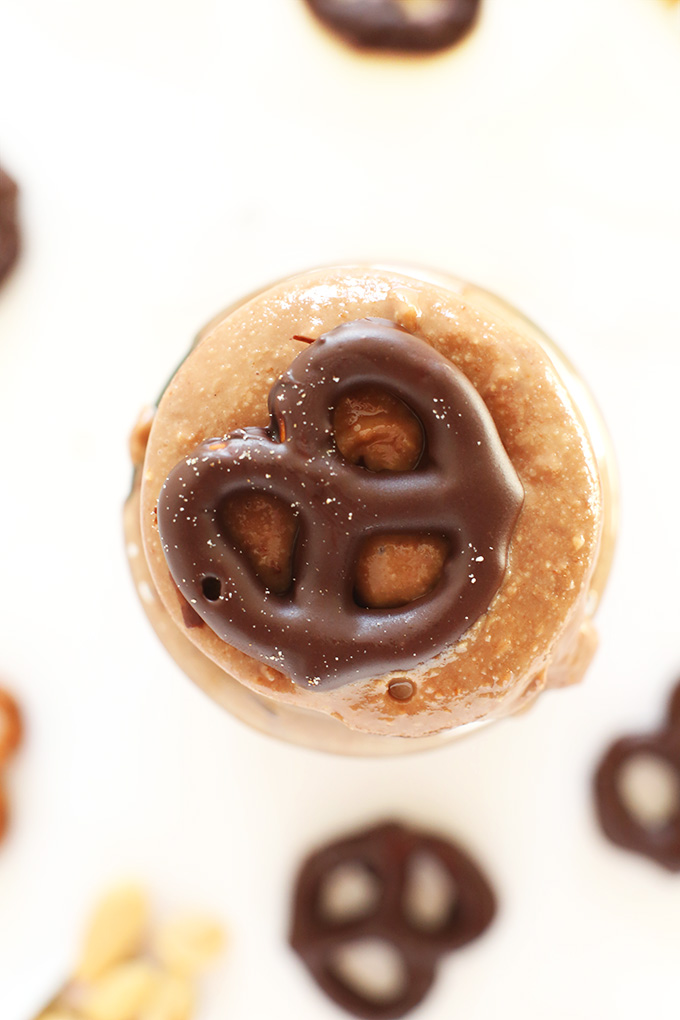 chocolate covered pretzel resting on a jar of homemade Chocolate Pretzel Peanut Butter