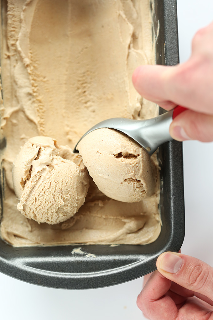Using an ice cream scooper to grab Vegan Chai Ice Cream from a pan