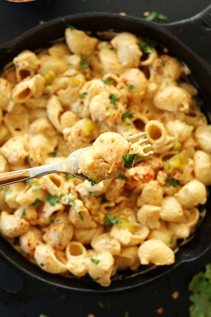 Holding a bite of healthy vegan Green Chili Mac n Cheese