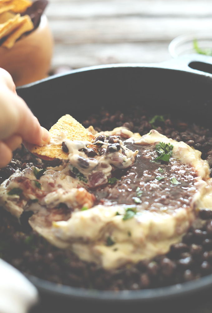 Using a chip to scoop up a bite of our Black Bean Raspberry Chipotle Dip