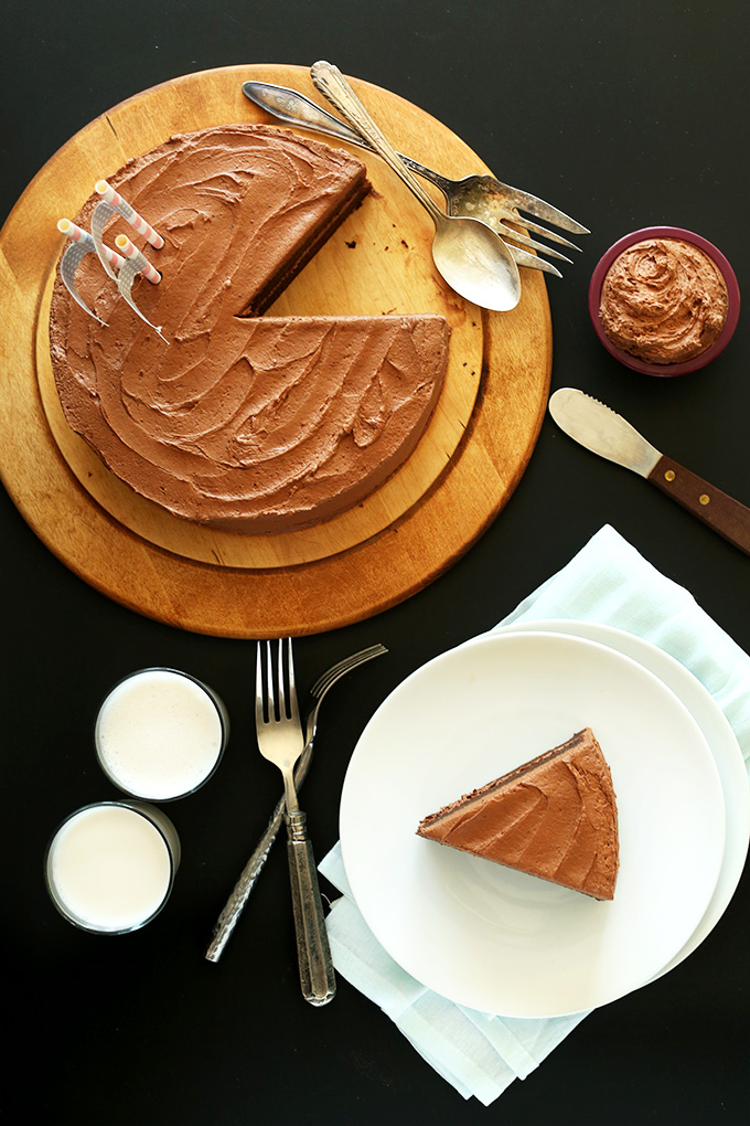 Slice of Vegan Chocolate Cake on a plate and the rest of the cake on a cutting board