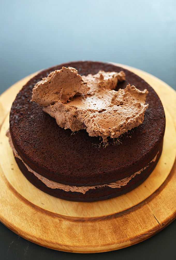 Vegan Chocolate Cake topped with chocolate frosting ready to be spread