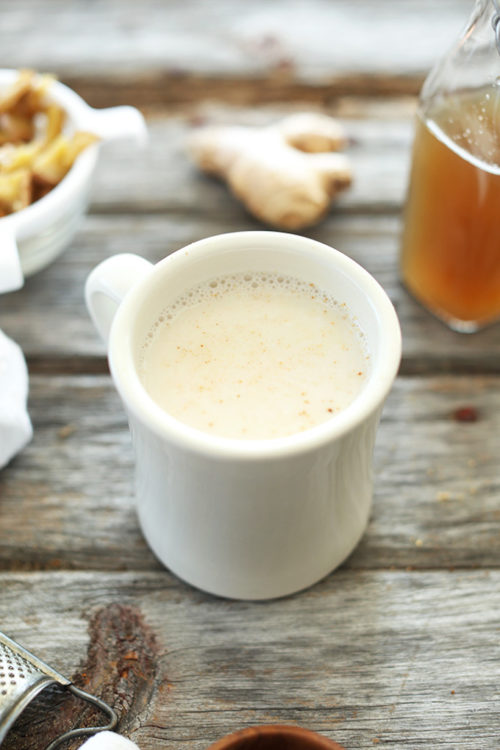 Mug of our Ginger Tea Latte recipe resting on a wood table