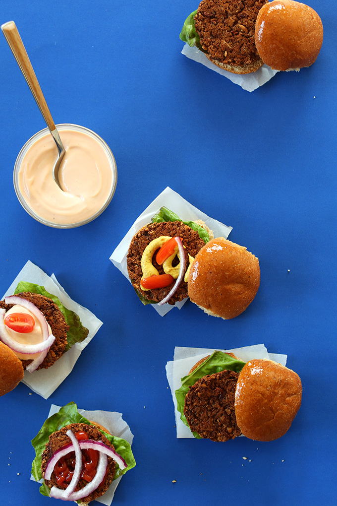 Veggie sliders on parchment squares and a bowl of sauce for topping