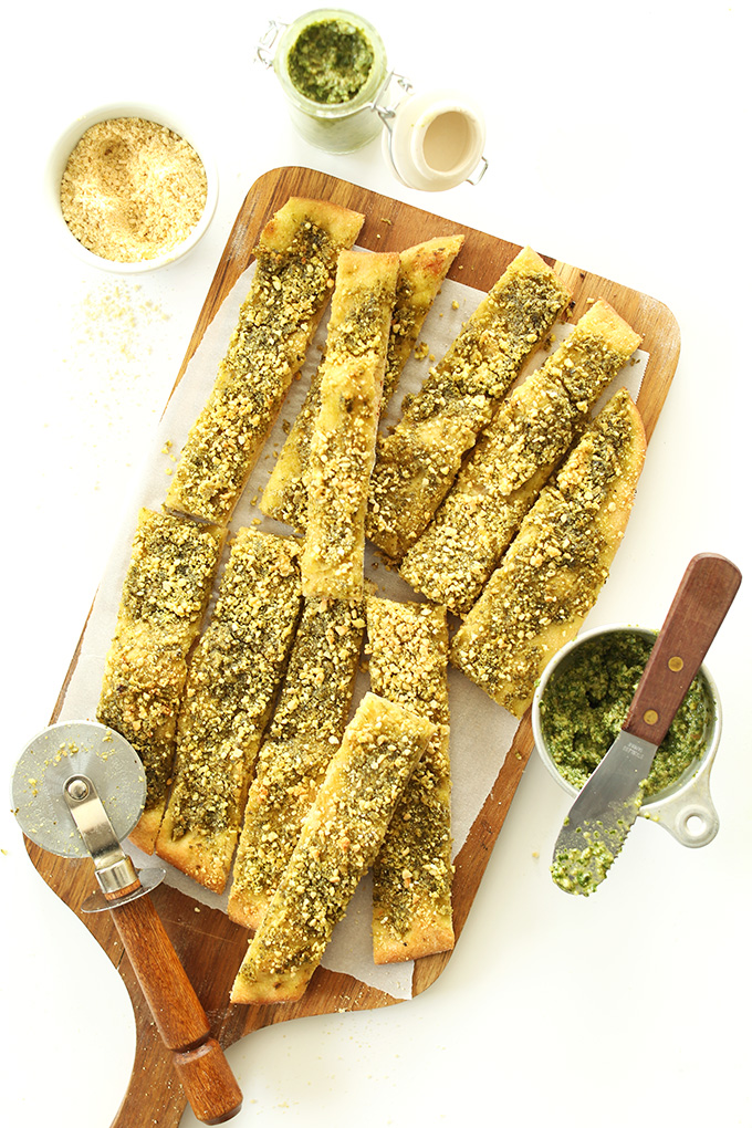 Cutting board filed with homemade Vegan Pesto Breadsticks