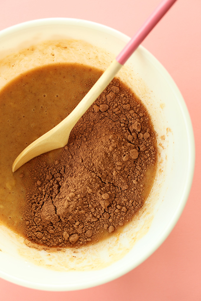 Mixing cocoa powder into wet ingredients for Chocolate Peanut Butter Banana Snack Bread