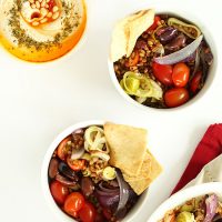 Two bowls of Mediterranean Wheat Berry Salad and a bowl of hummus