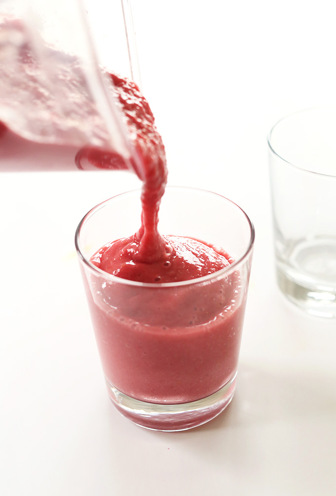 Pouring a delicious creamy vegan smoothie that tastes like summer in a cup