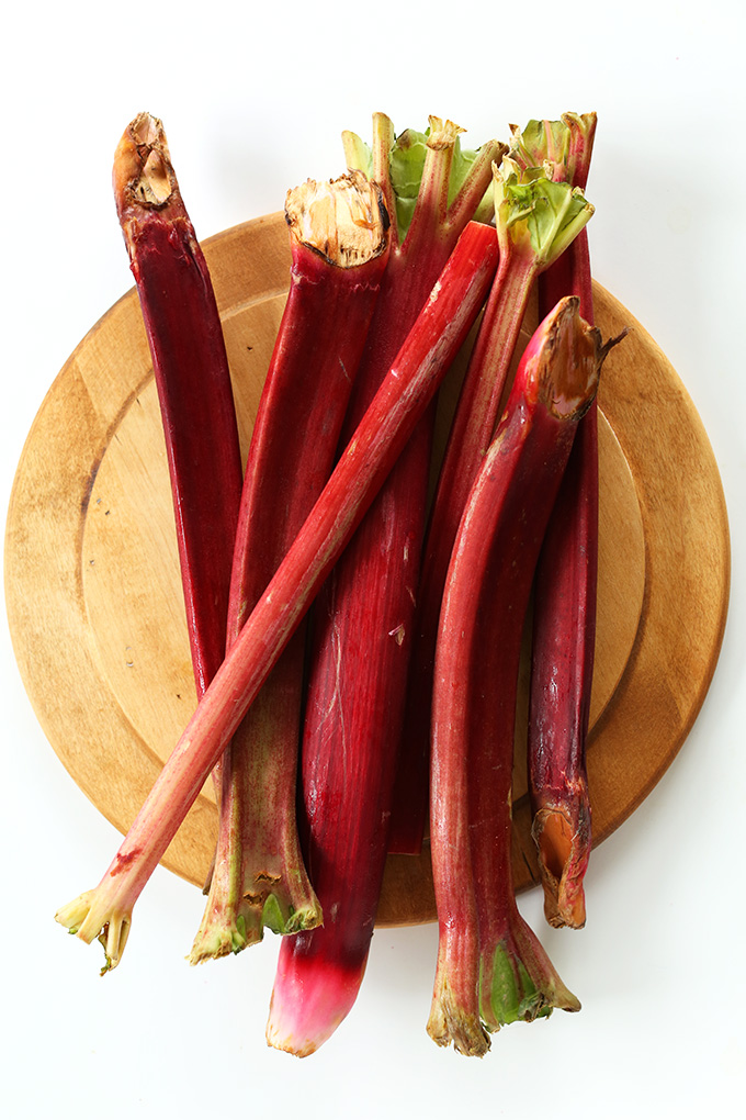 Stalks of fresh rhubarb on a wood cutting board