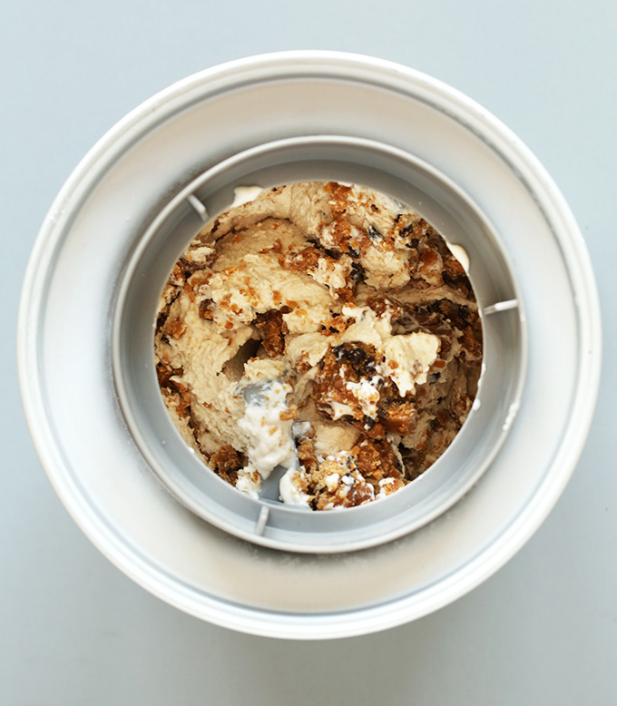 Ice cream maker filled with ingredients for making Easy Vegan Peanut Butter Chocolate Chip Cookie Dough Ice Cream