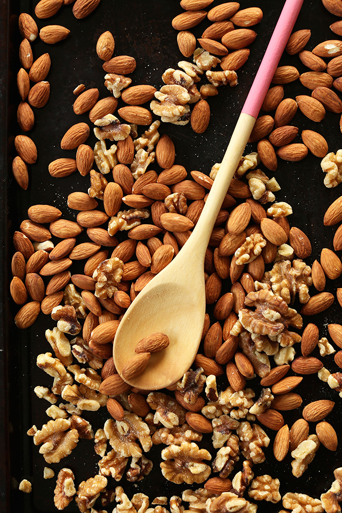 Almonds and walnuts on a baking sheet for making homemade nut butter