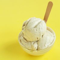Bowl with two scoops of Vegan Salted Bourbon Caramel Ice Cream and a wooden spoon