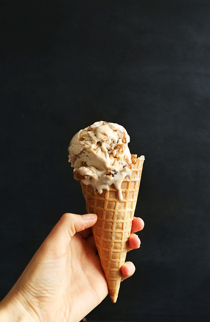Holding up a waffle cone filled with a scoop of homemade Vegan Chocolate Chip Cookie Dough Ice Cream