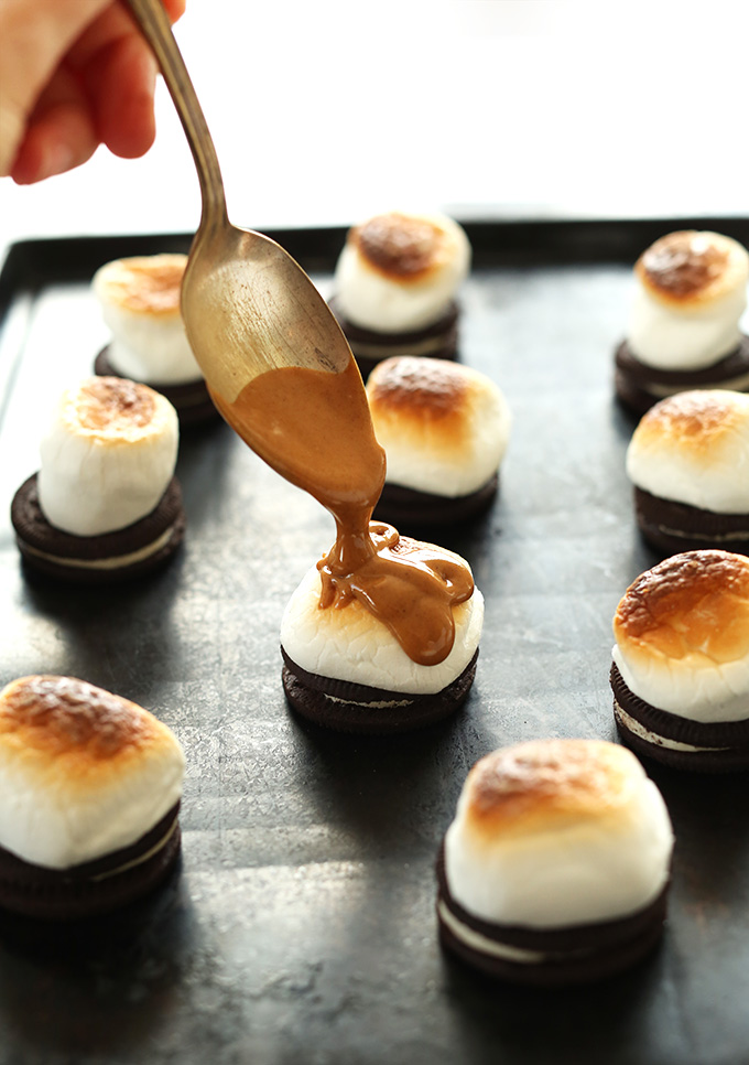 Spooning peanut butter onto toasted marshmallows for Peanut Butter S'MOREOS