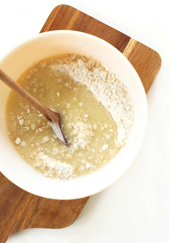 Using a wooden spoon to stir ingredients for homemade Vegan Gluten-Free Waffles