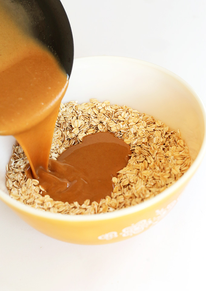 Pouring wet ingredients into a bowl of dry ingredients for our Peanut Butter Chocolate Chip Granola recipe