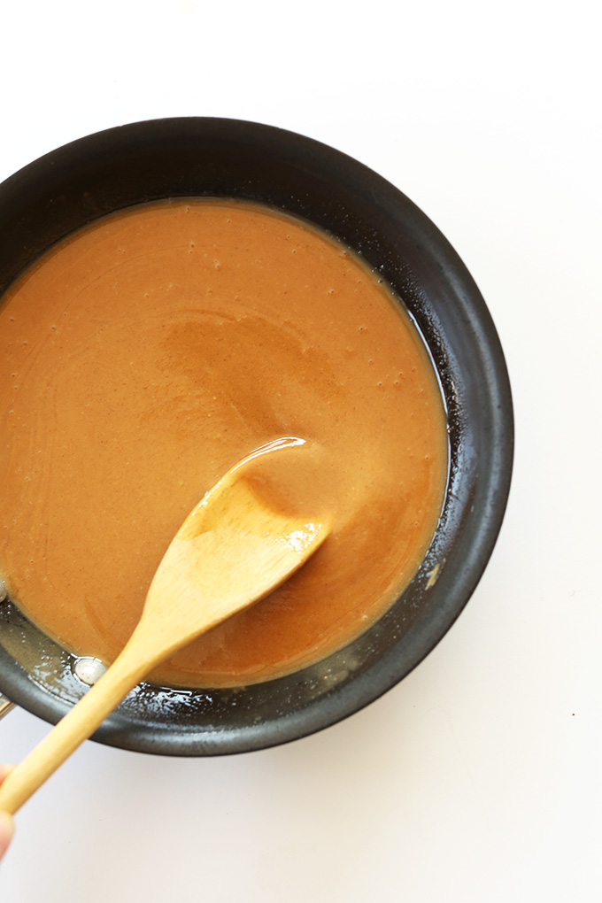 Stirring a warm peanut butter mixture for homemade Vegan Peanut Butter Granola