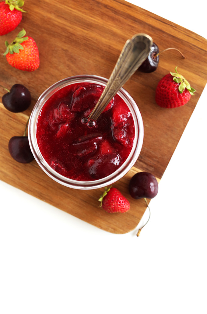 Cutting board with a jar of our simple homemade fruit compote recipe