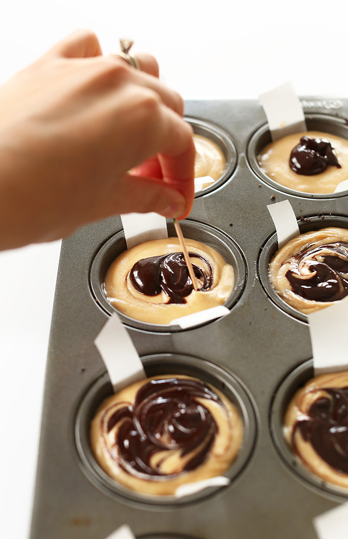 Using a toothpick to create a chocolate swirl in Vegan Peanut Butter Cup Cheesecakes