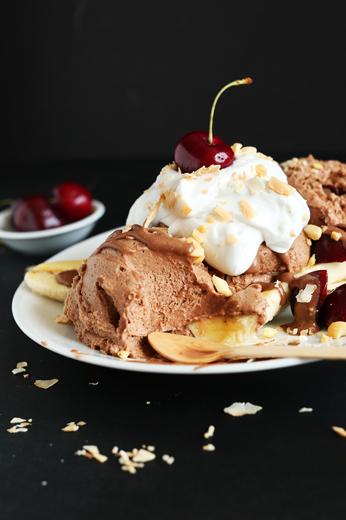 Partially eaten Vegan Banana Split with coconut whip and a cherry on top
