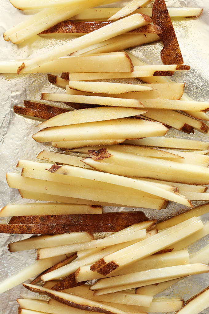 Matchstick cut potatoes resting on tin foil for making our homemade french fries recipe