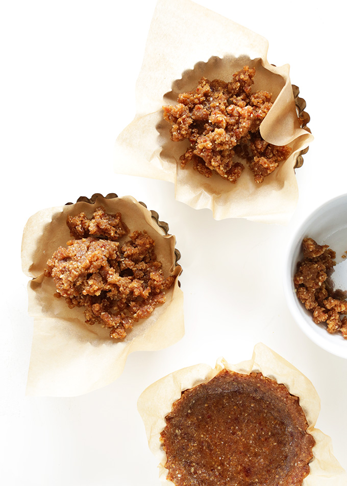 Parchment-lined mini tart pans filled with crust for Lemon Fruit Tarts