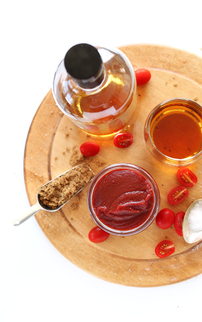 Cutting board with homemade ketchup and ingredients used to make it