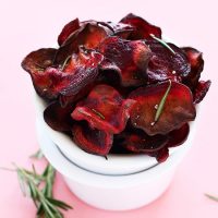 Stack of bowls holding a batch of Baked Rosemary Beet Chips