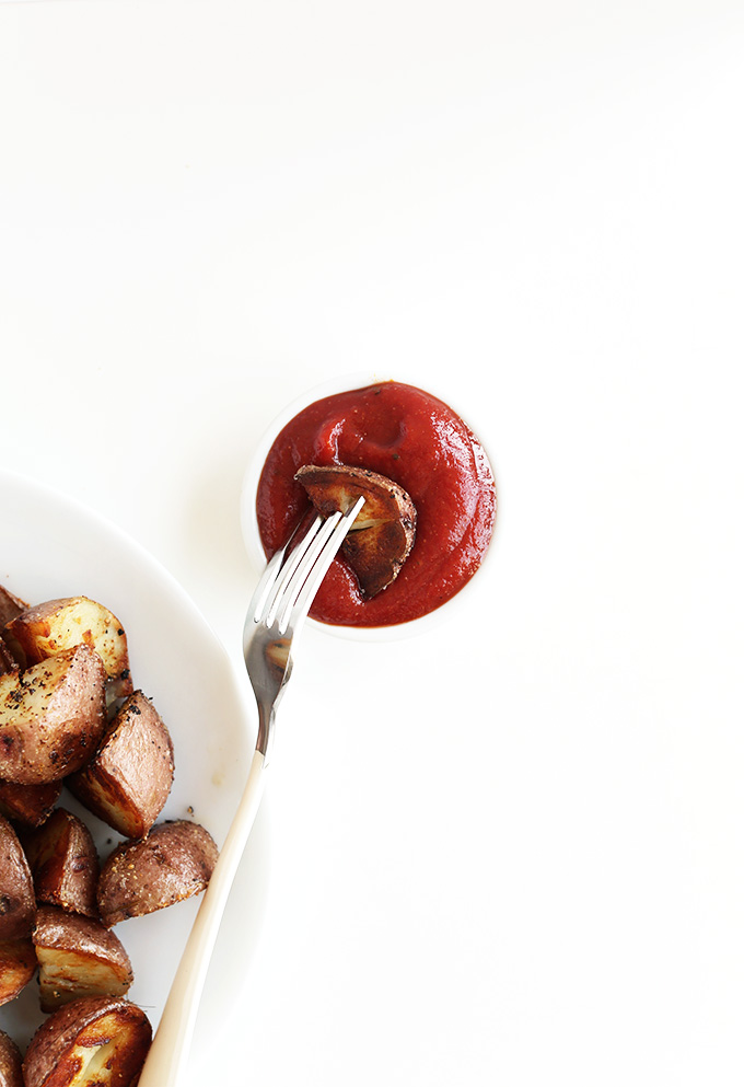 Dipping a crispy vegan Breakfast Potato into a dish of ketchup