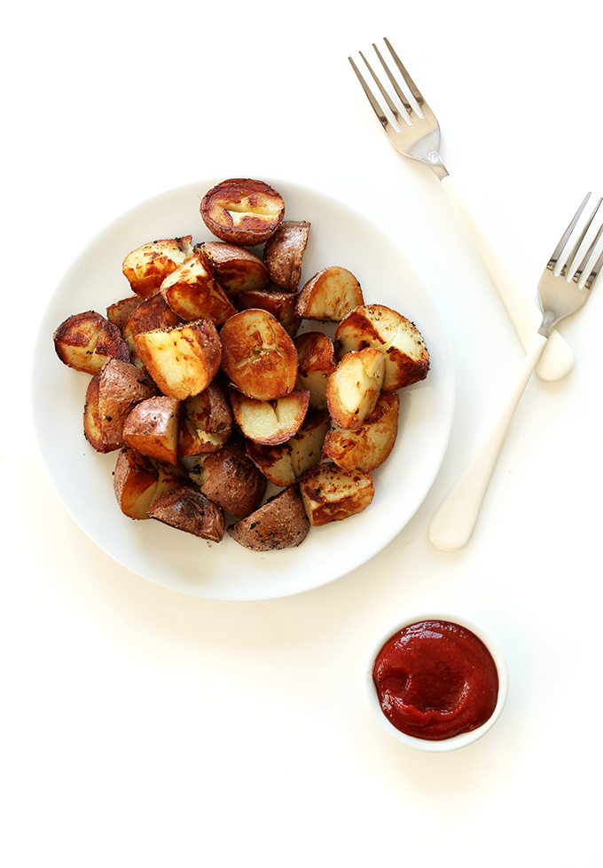 Plate of crispy vegan Breakfast Potatoes with a small bowl of ketchup