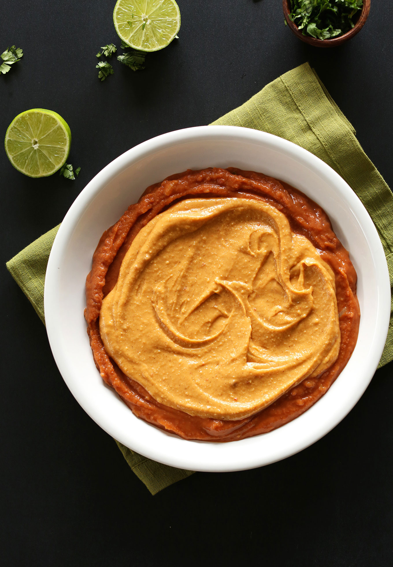 Bowl of bean and vegan cheese layers for 7-Layer Vegan Mexican Dip