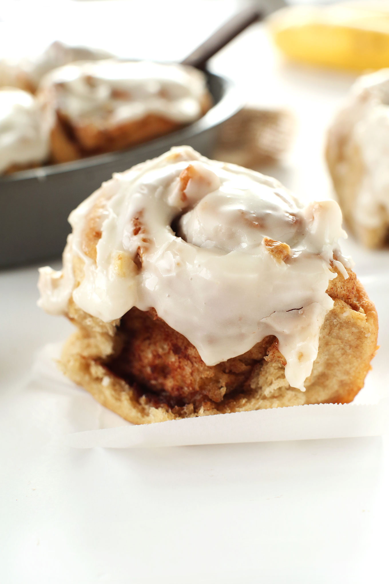 Close up shot of a vegan Banana Bread Cinnamon Roll with icing