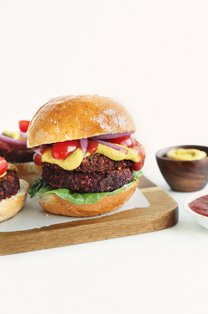 Black Bean Beet Burger on a bun with lettuce, ketchup, mustard, and onion