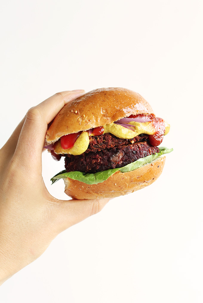 Holding up a hearty vegan Black Bean Beet Burger