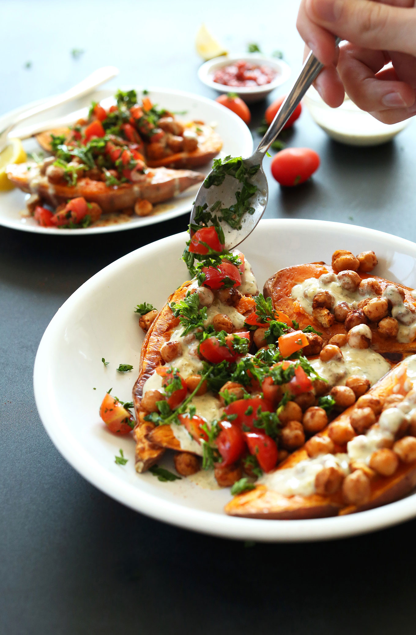 Using a spoon to add tabbouleh to Mediterranean Baked Sweet Potatoes